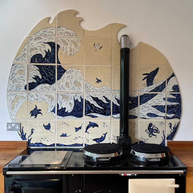 Beuatiful bespoke interior splachback depicting blue waves, set behind range cooker in kitchen.