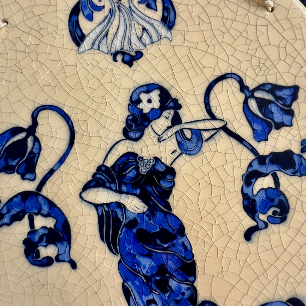 Decorative ceramic hand carved tile with blue Art Nouveau Lady surrounded by a floral design with a crackle glaze background.
