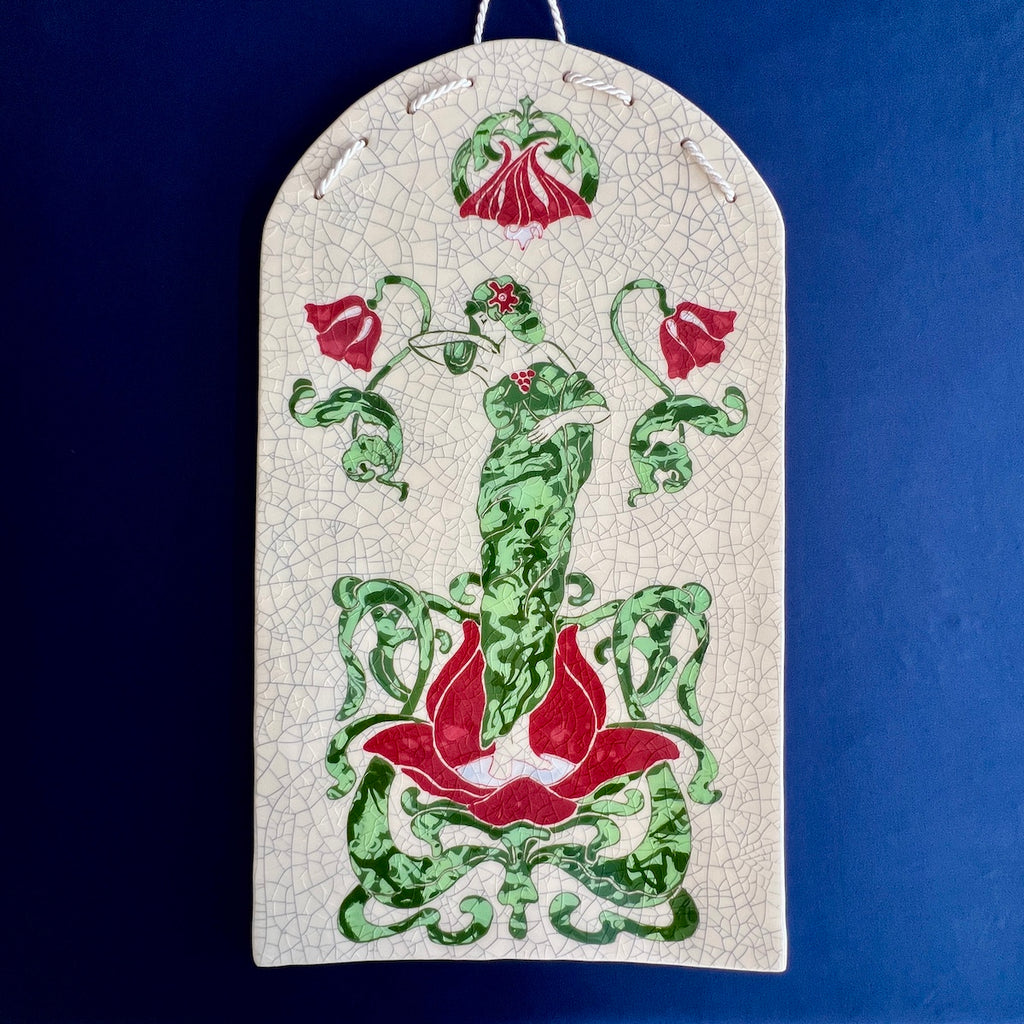 Decorative ceramic hand carved tile with green and red Art Nouveau Lady surrounded by a floral design with a crackle glaze background.
