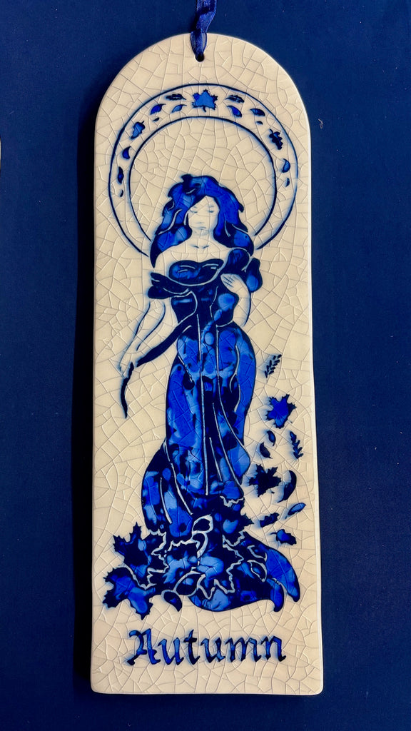 Arch ceramic tile hand carved with Art Nouveau woman representing Autumn on a crackle glaze background.