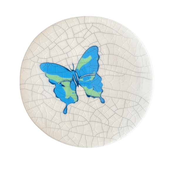 Round ceramic coaster with a blue butterfly design on a crackle glaze background