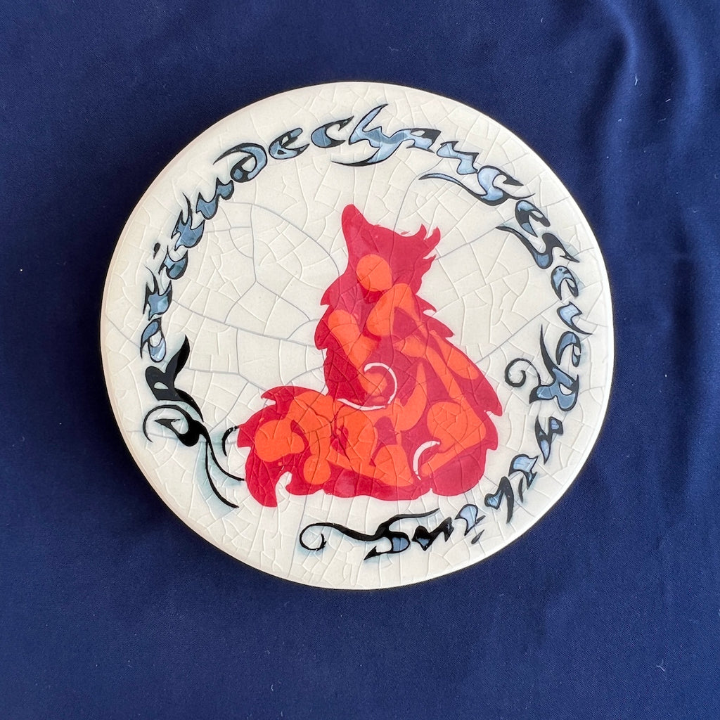 Round coaster with red and orange fox design on a crackle glaze background with the words "Gratitude changes everything."