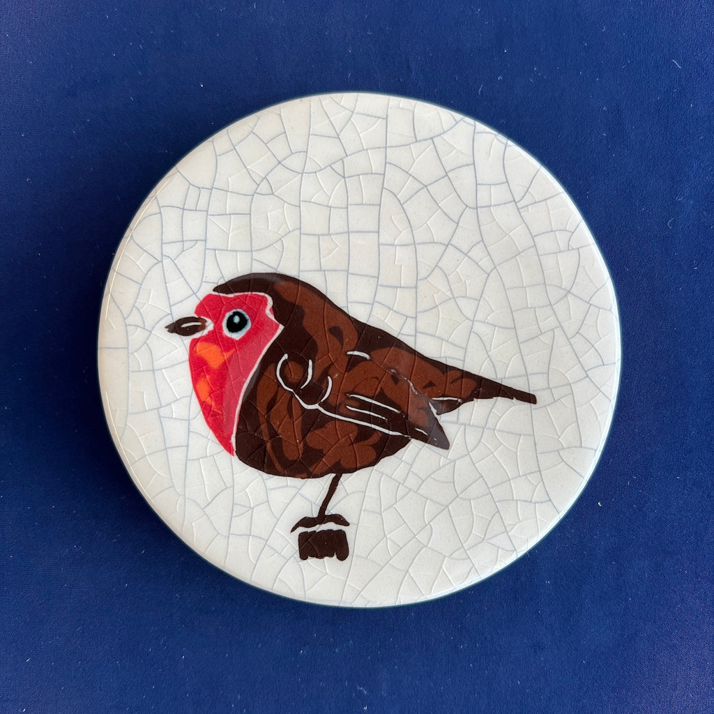 Round ceramic coaster with a robin design on a crackle glaze background