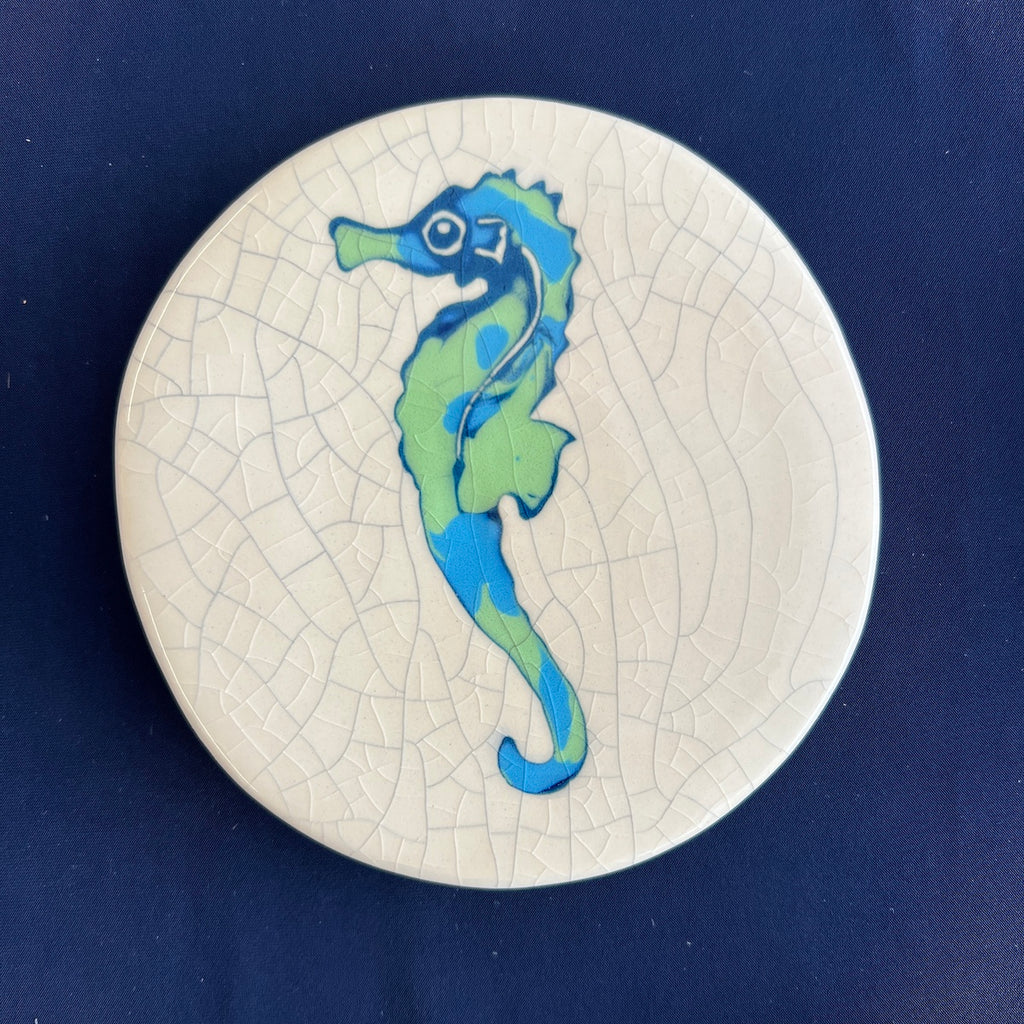 Ceramic coaster with a seahorse design on a blue background