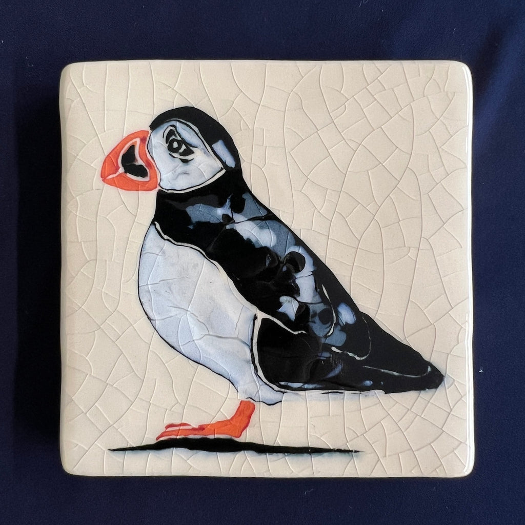 Square ceramic coaster with a puffin design on a crackle glaze beige background